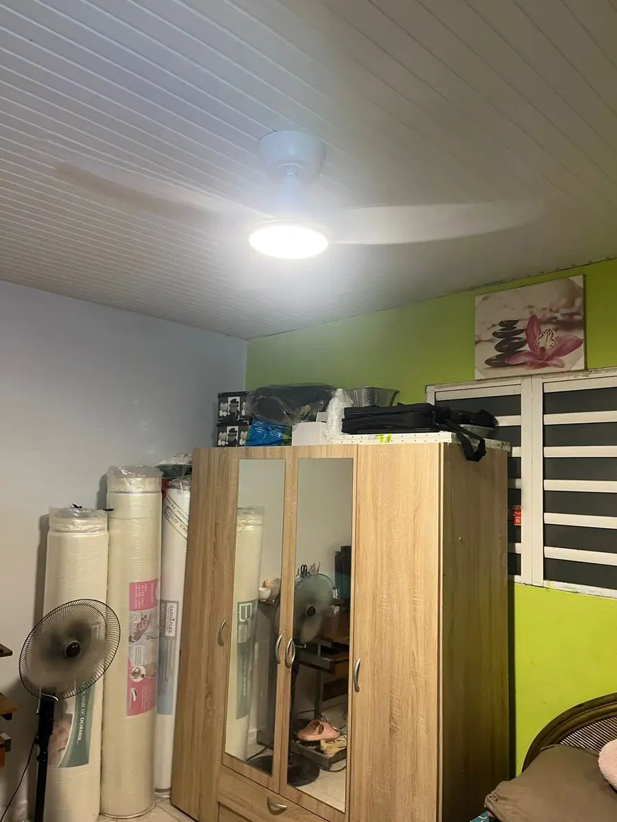 Après l'installation d'un brasseur d'air par Mes Primes Rénovations : une pièce de rangement, ampoule nue remplacée