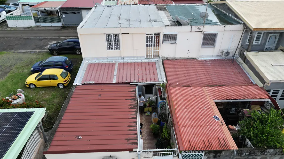 Chantier de toiture réalisé par Mes Primes Rénovations à Fort-de-France : couvertures mixtes tôle et bac acier sur un quartier dense