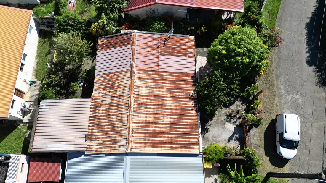 Chantier de toiture réalisé par Mes Primes Rénovations à Les Anses-d'Arlet : toiture fortement corrodée, puis dépose complète avec l'équipe sur le chantier