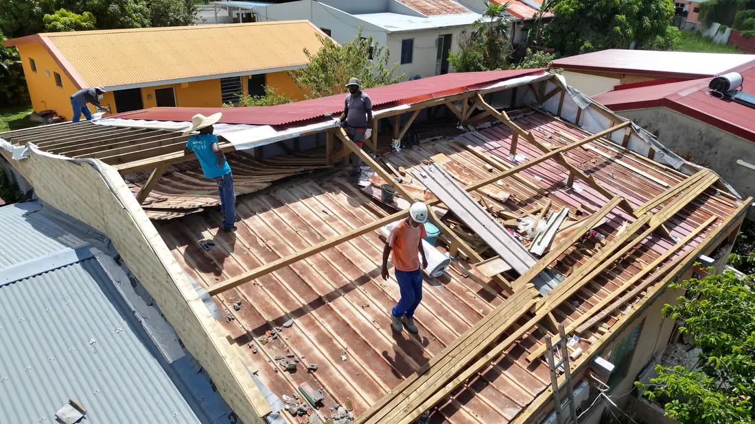 Chantier de toiture réalisé par Mes Primes Rénovations à Les Anses-d'Arlet : toiture fortement corrodée, puis dépose complète avec l'équipe sur le chantier