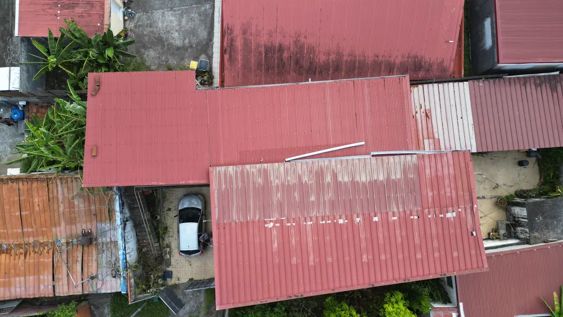 Chantier de toiture réalisé par Mes Primes Rénovations à Fort-de-France : reprise de couverture sur un secteur où les toitures voisines sont très corrodées